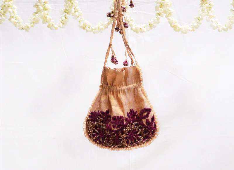 Saucy gold,Kanjeevaram tissue, with maroon velvet applique potli bag.