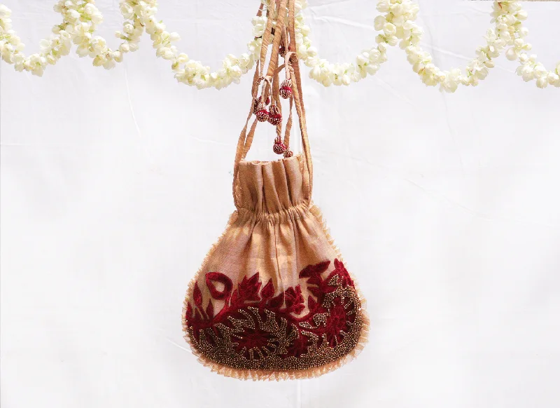 Saucy gold,Kanjeevaram tissue, with red velvet applique potli bag.